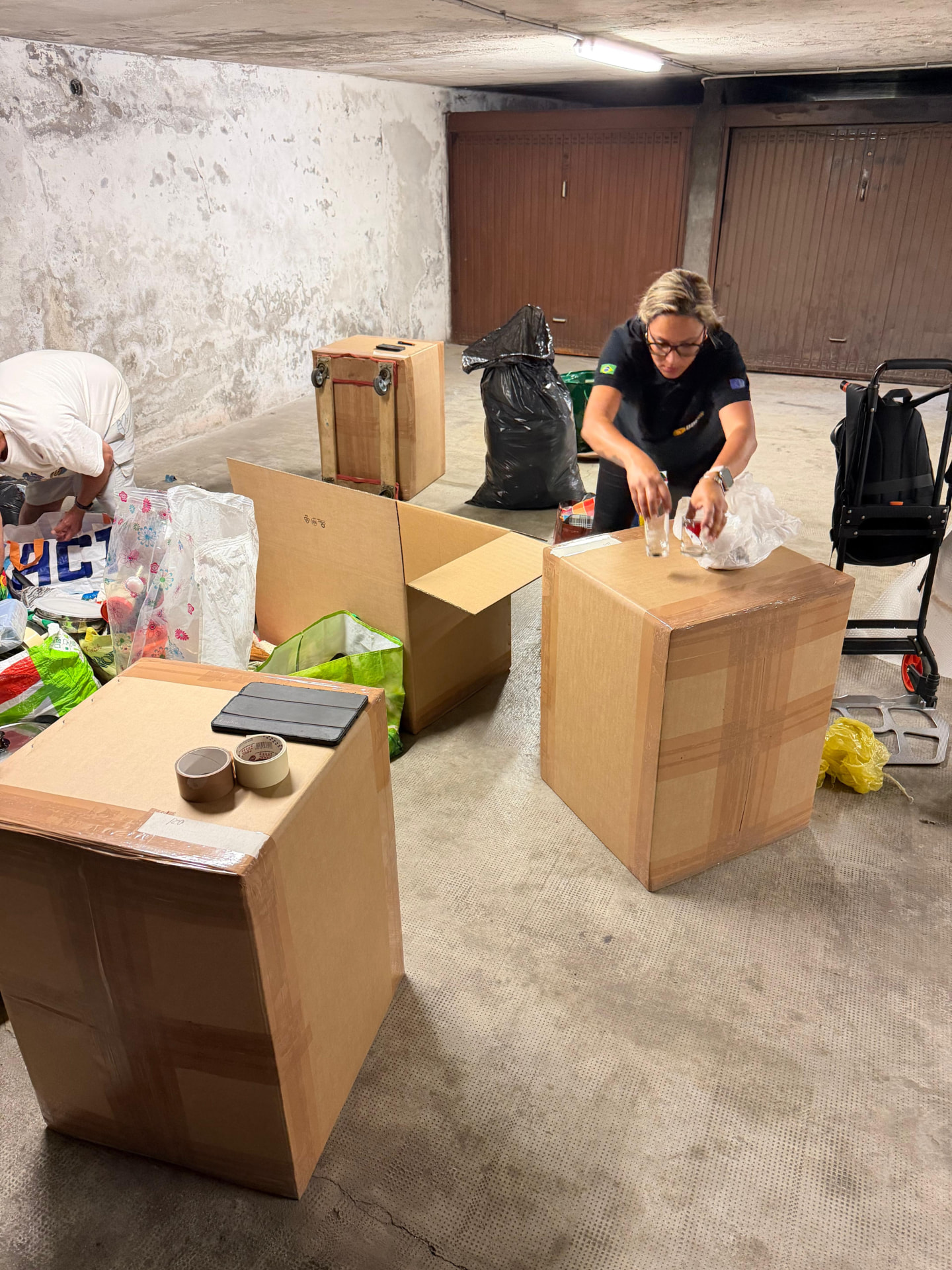 Equipe embalando caixas de mudança em uma garagem