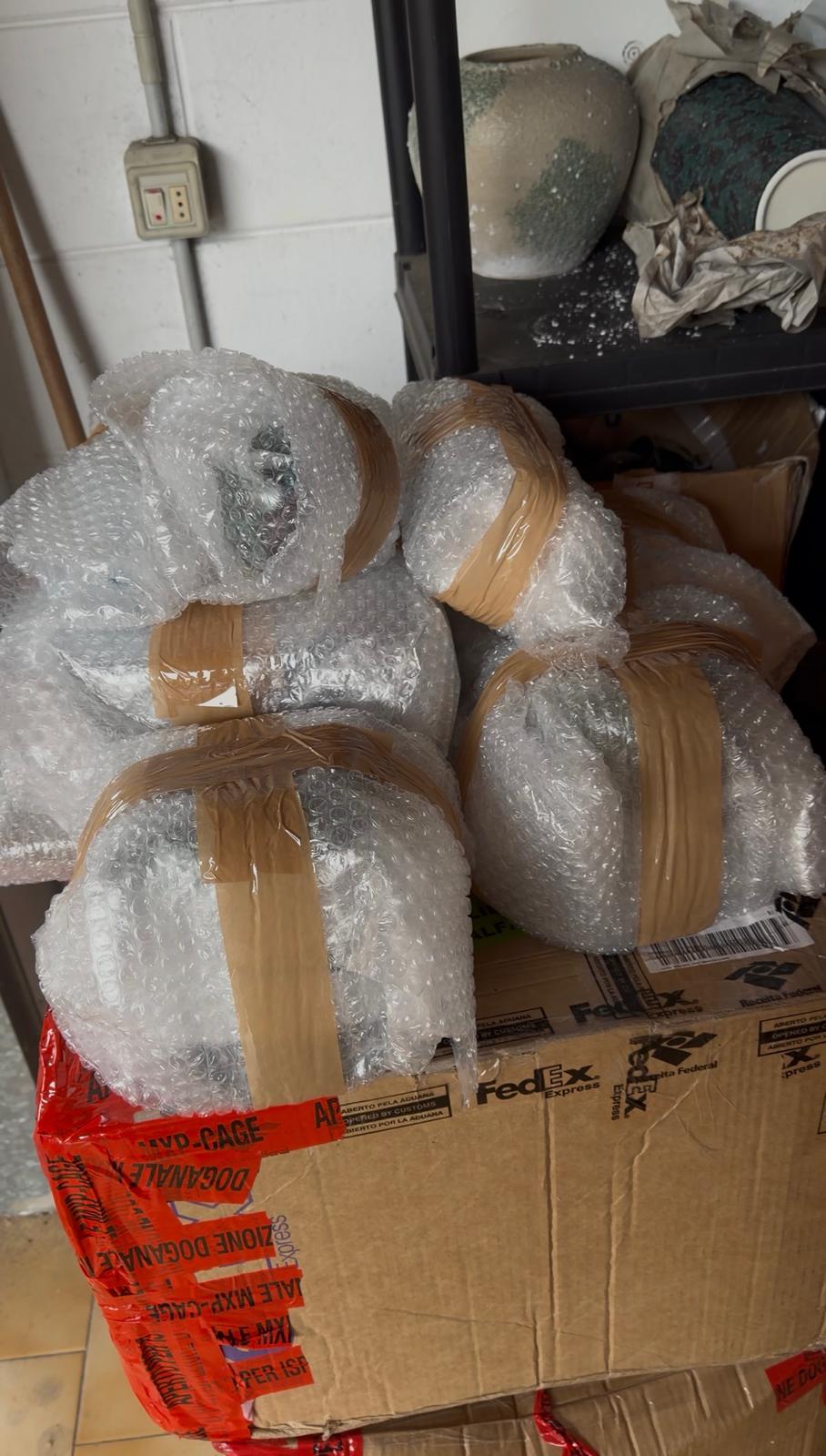 Objetos frágeis embalados com plástico bolha sobre caixas