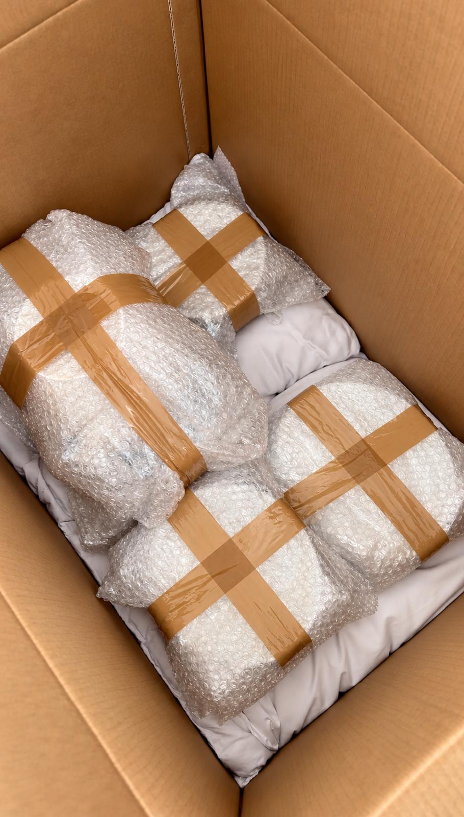 Objetos frágeis embrulhados em plástico bolha dentro de uma caixa de papelão