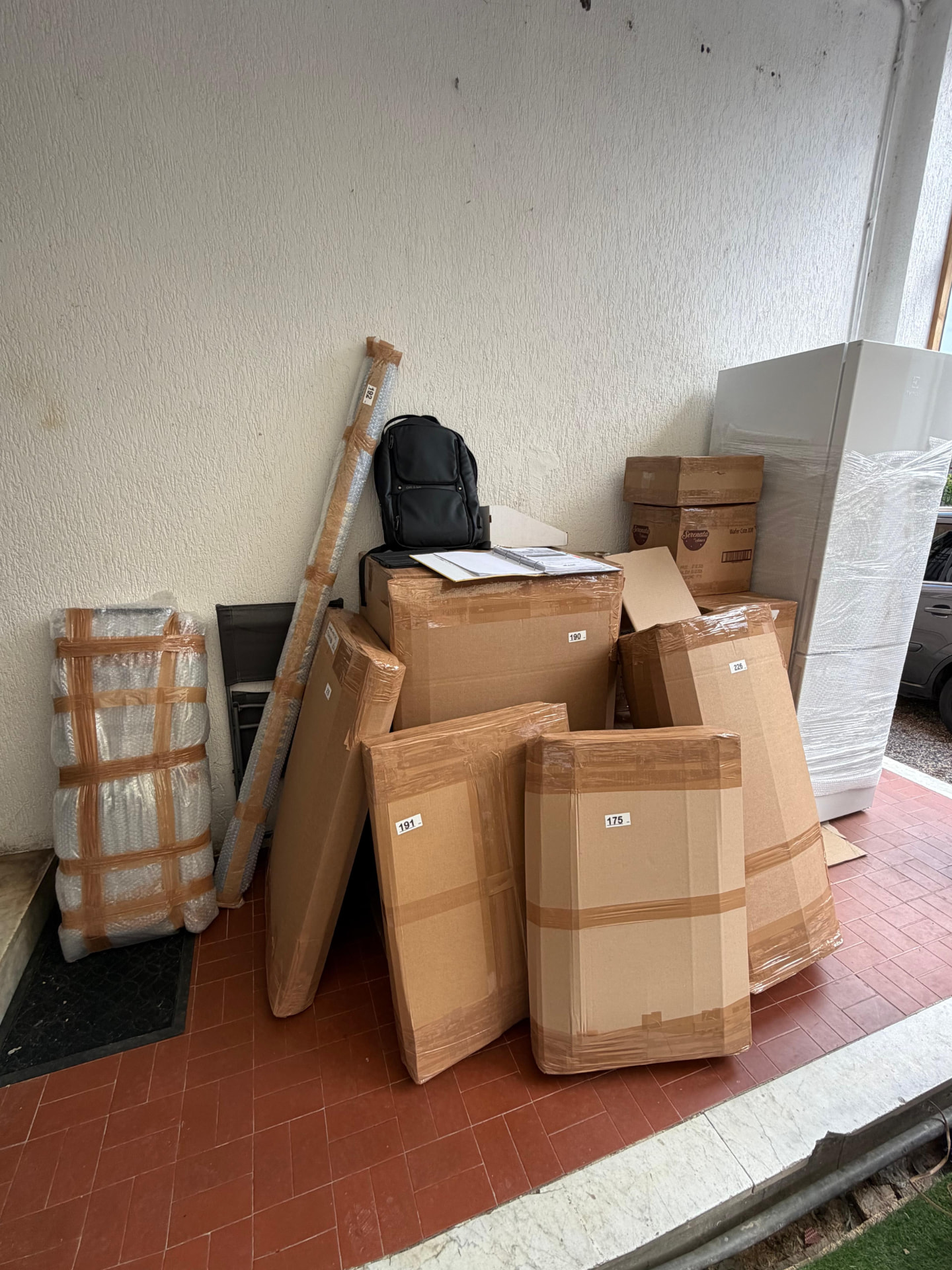 Móveis e caixas de mudança embalados com plástico bolha e papelão em uma varanda