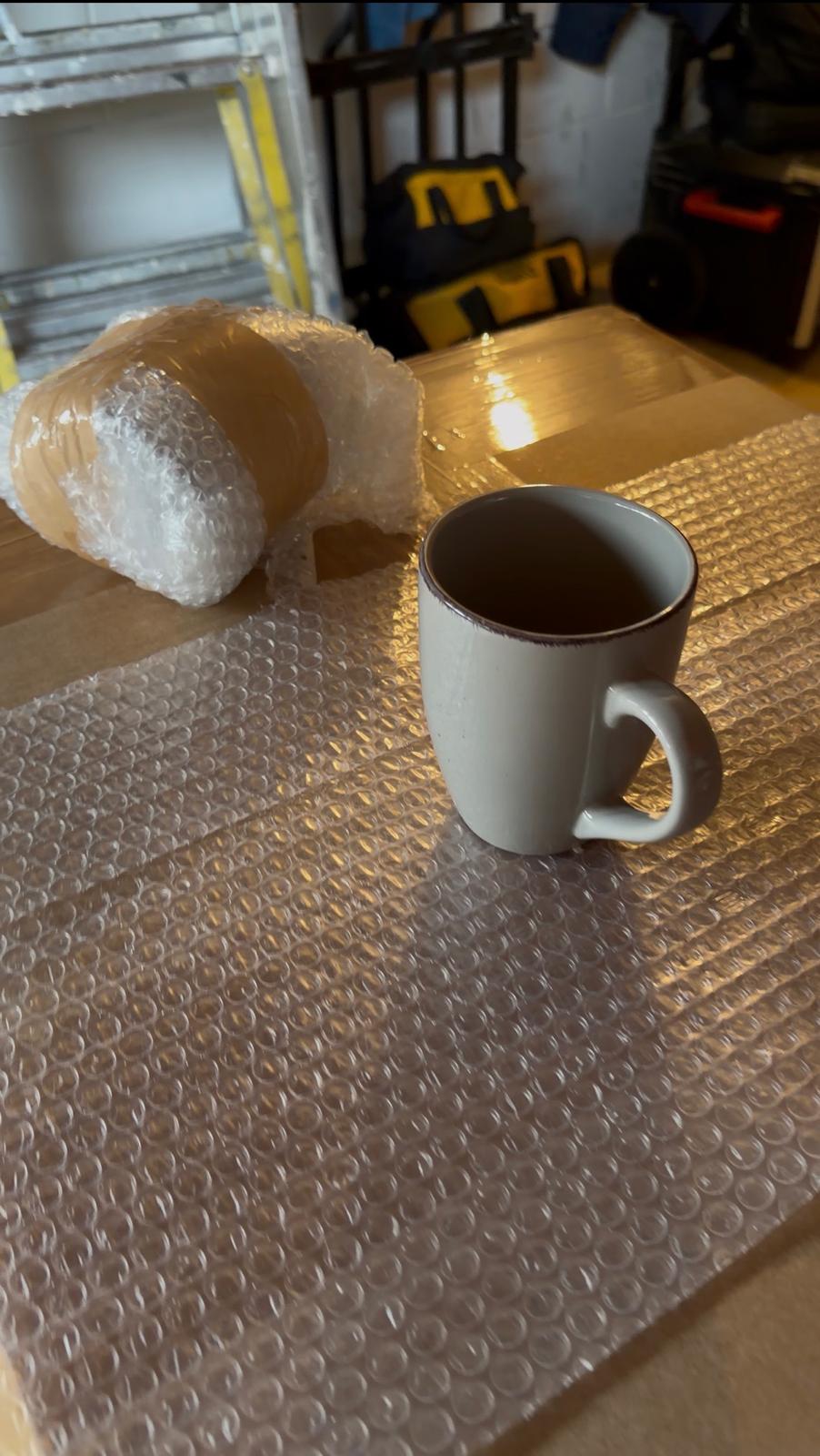 Caneca e itens de cozinha embalados com plástico bolha